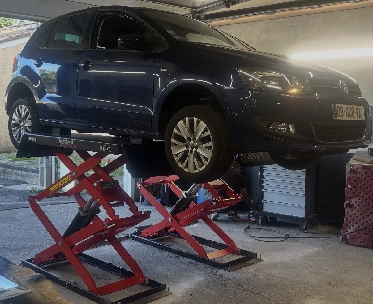 Pont ciseaux sous un véhicule dans un atelier